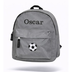 Grå børnerygsæk med navn broderet på forsiden.