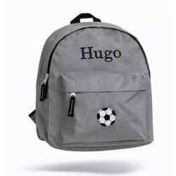 Grå børnerygsæk med navn broderet på forsiden.